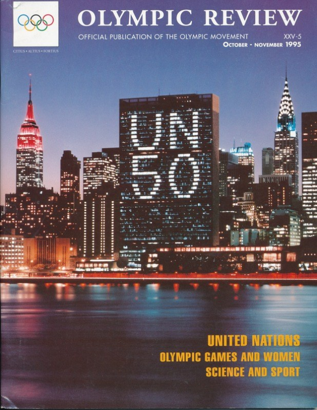 Buch mit dem Titel "Olympische Übersicht Offizielle Veröffentlichung der Olympischen Bewegung" mit einer Stadtansicht auf dem Cover, das auf einer flachen Oberfläche liegt.