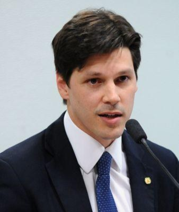 Ein Mann im Anzug und mit Krawatte spricht in ein Mikrofon an einem Rednerpult, wahrscheinlich um ein Regierungsgesetz zur Verbot des Internets zu unterstützen.