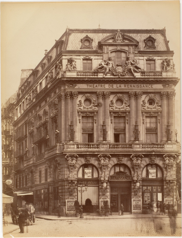 Altes Foto des Théâtre de la Renaissance in Paris mit seiner prächtigen Fassade, die von Fenstern, Säulen, Bögen und Skulpturen geschmückt ist, sowie Passanten und Pferdefuhrwerken auf der Straße und einem sichtbaren Himmel.