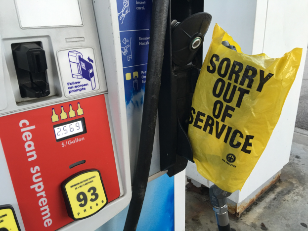 Tankstelle mit einem 'Sorry Out of Service'-Schild und einer gelben Treibstoffabgabeabdeckung.