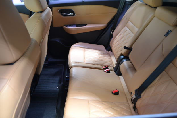 Innenraum eines Autos mit hellbraunen Ledersitzen, Sicherheitsgurten, Türen und Fenstern, der einen eleganten und stilvollen Look hat.