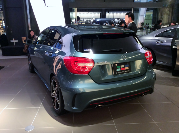 Mercedes-Benz A-Klasse Limousine mit glänzender schwarzer Lackierung, Chromakzenten und Aluminiumrädern, die auf der IAA in Frankfurt umgeben von Menschen gezeigt wird.