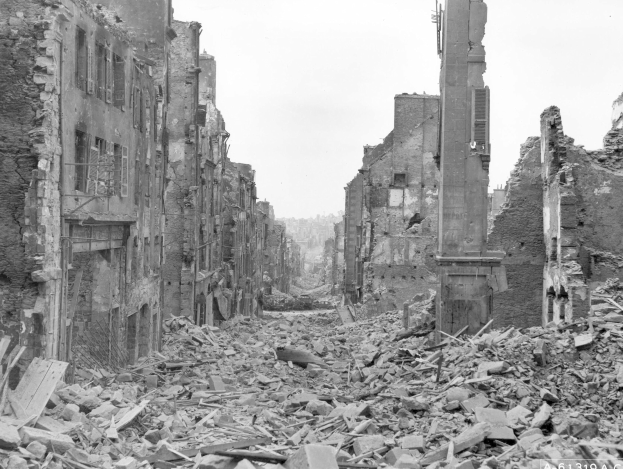 Schwarz-weiß-Foto einer zerstörten Stadtstraße mit Gebäuden auf beiden Seiten und verstreuter Trümmer von Bombenschäden in Berlin.