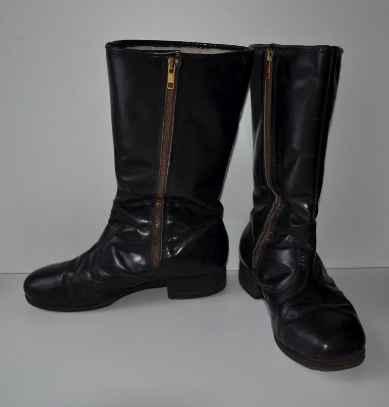 Schwarze Lederstiefel mit silbernen Reißverschlüssen auf einem weißen Hintergrund, mit einem glänzenden Finish.