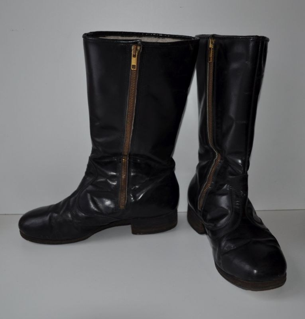 Schwarze Lederstiefel mit silbernen Reißverschlüssen auf einem weißen Hintergrund, mit einem glänzenden Finish.
