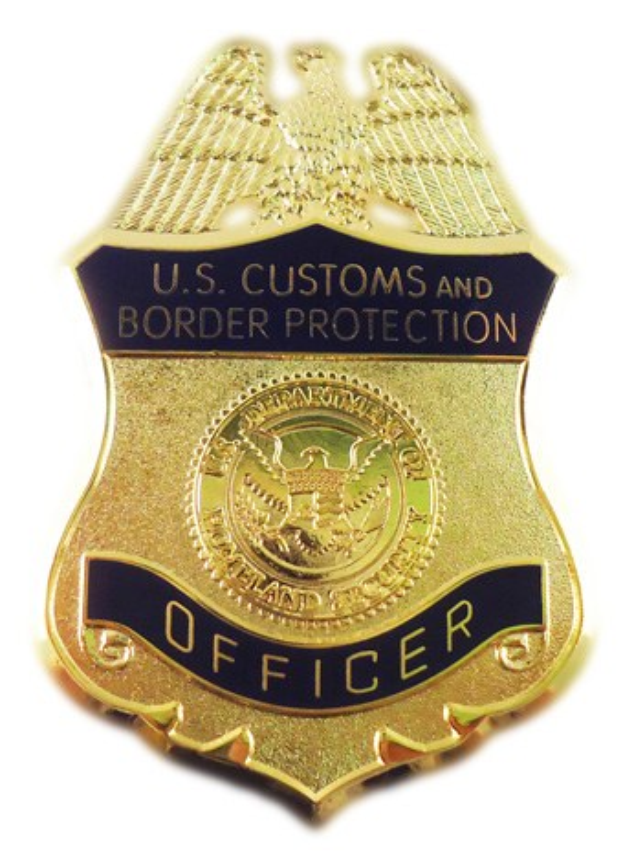 Goldene Abzeichen mit der Aufschrift "U.S. Customs and Border Protection Officer" auf einem weißen Hintergrund.