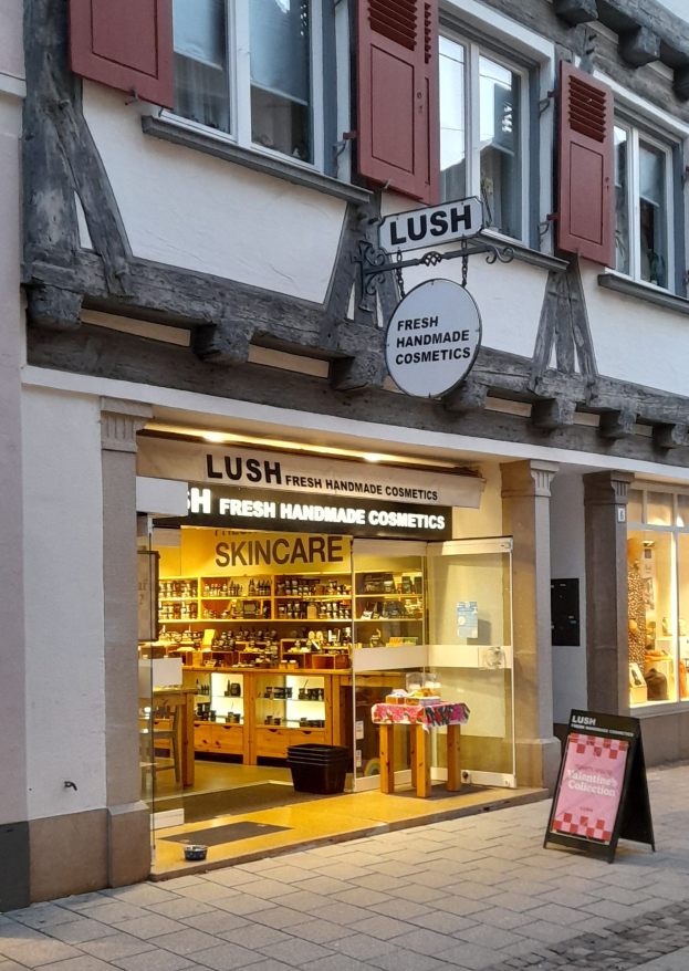 Verkaufsfläche von "Lush Skincare" mit Innenregalen, Schreibtisch, Stuhl und sichtbarem Boden.